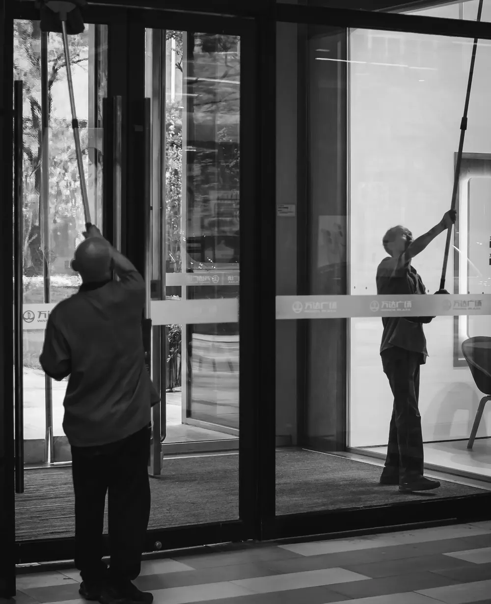 Équipe de nettoyage professionnel intervenant sur des surfaces vitrées